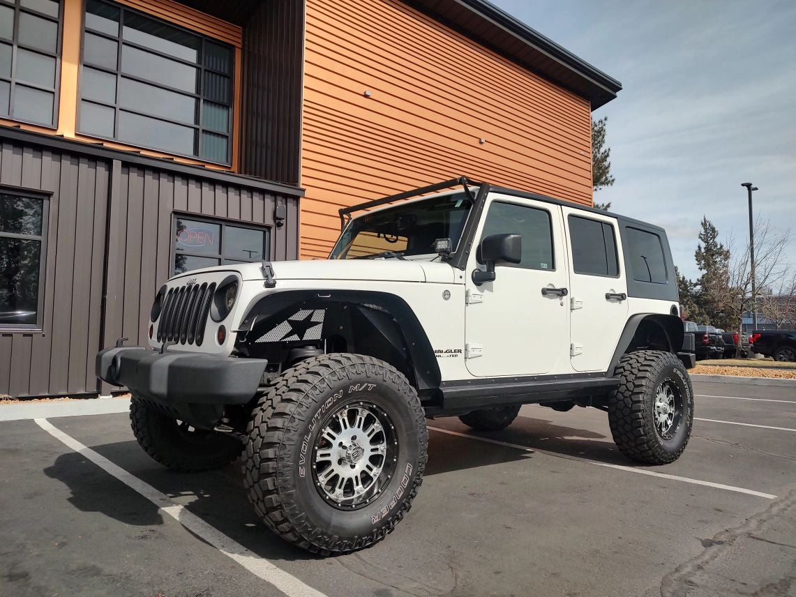 2009 Jeep Wrangler Unlimited Rubicon in Stone White Clearcoat — front three-quarter view